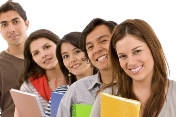 Group of students lined up holding notebooks isolated on a white background